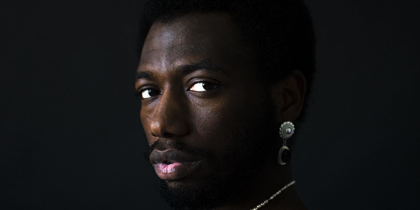 Profile view of a face turning to camera, set against a black background.