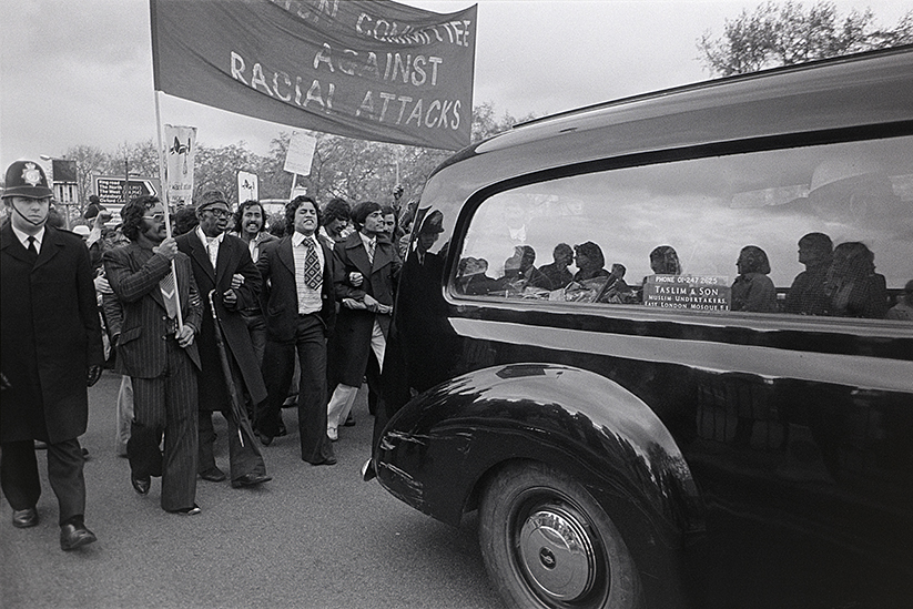 Demonstrators march behind a hearse 